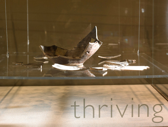 Photo of broken pot with text 'thriving' below