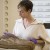 Woman handling fishing net artifact.