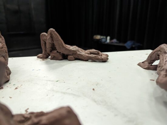 Clay figure reclining on the edge of a table