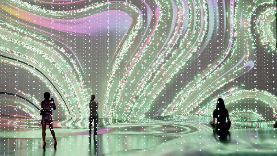 Wavy shapes displayed on a large digital screen in a room