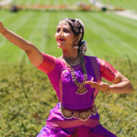 Woman dancing in field. By Harry Gregory