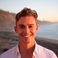 A person with short hair smiling at the camera