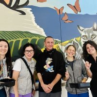 Staffers Jeanie Liang, Hyun Lee, Amy Huffaker, and Antonia Dapena-Tretter helped to paint a mural created by artist Ryan Martinez (center), featuring California landscapes and animals.