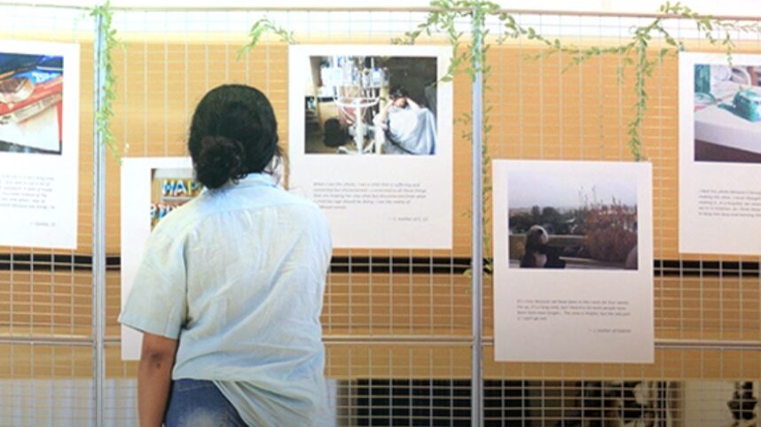 Student looking at artworks on a standing display