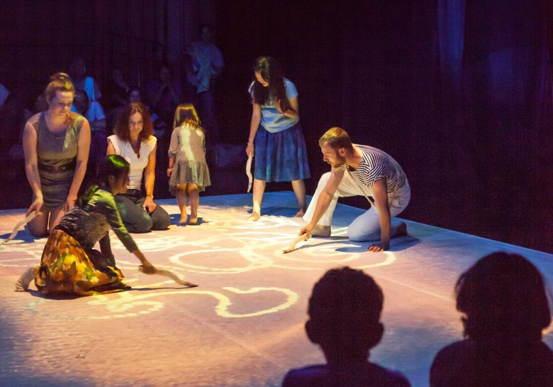 Photo of performers and children on stage.