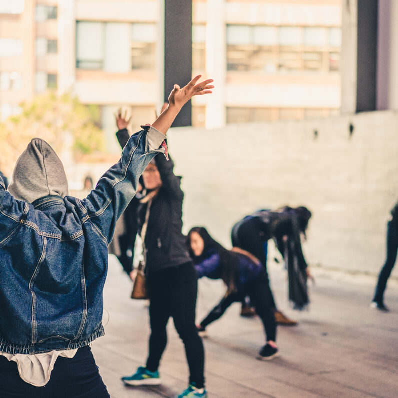 a group of people in casual clothing strike poses in an open warehouse space