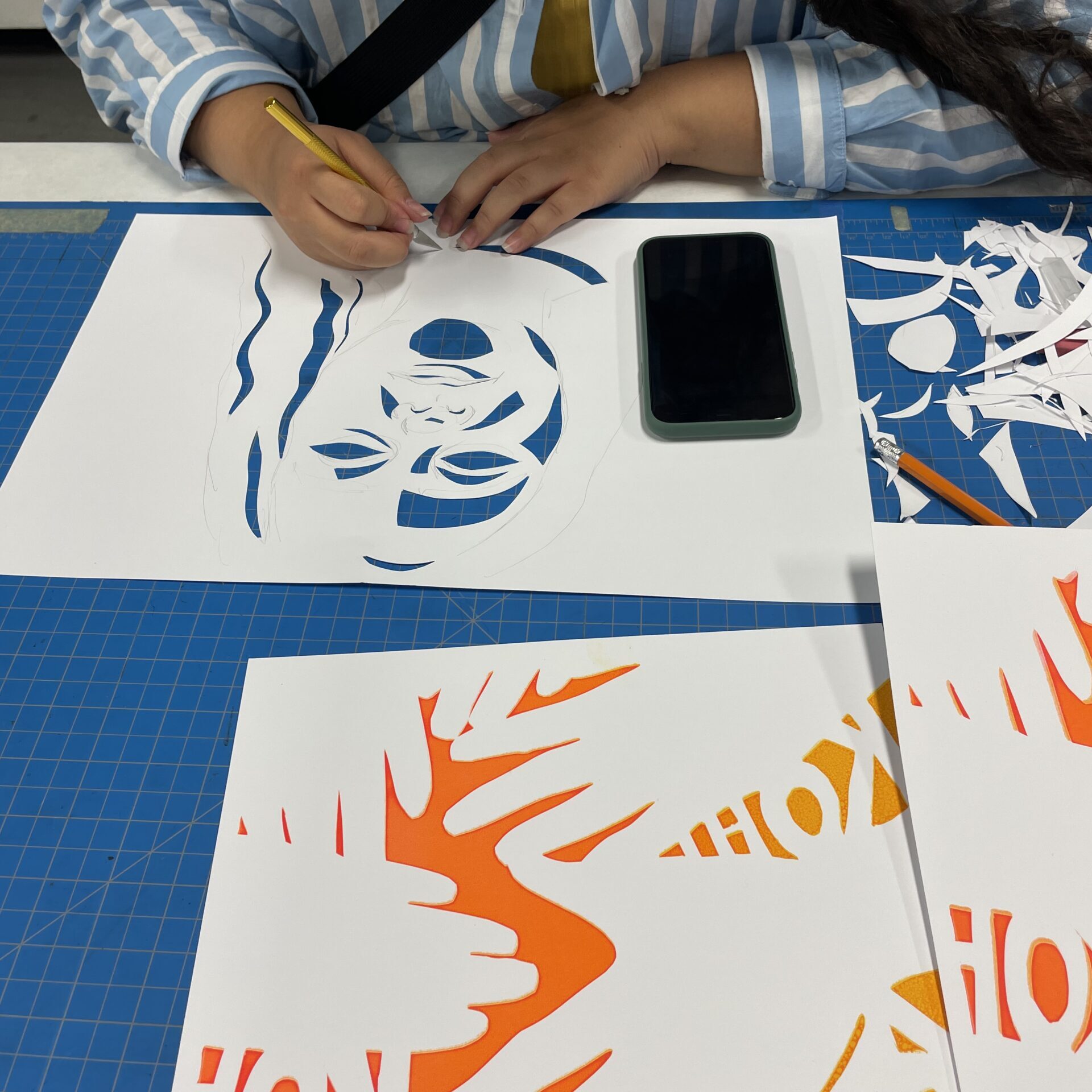 a student working on brightly colored screenprints