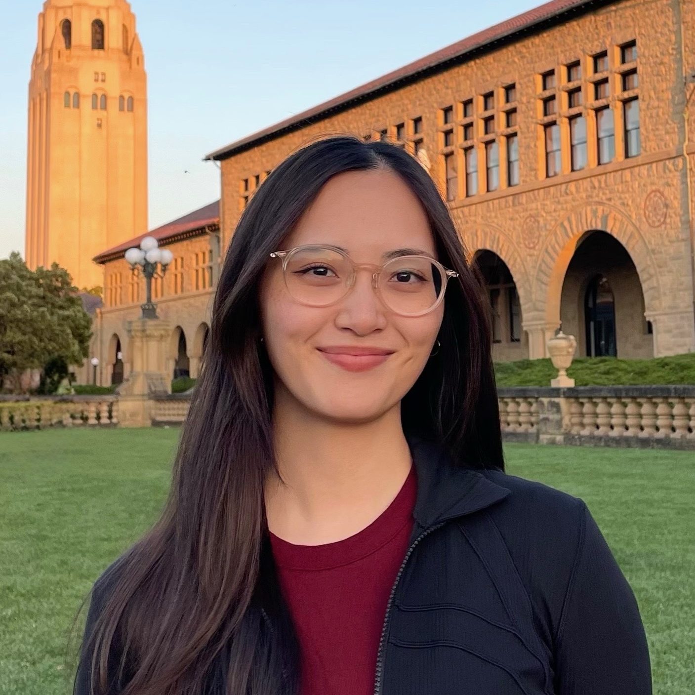A photo of Maika Jones wearing a dark jacket and standing in front of Hoover Tower