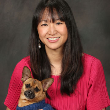 photo of Marci Kwon in a pink blouse with a small dog on her lap