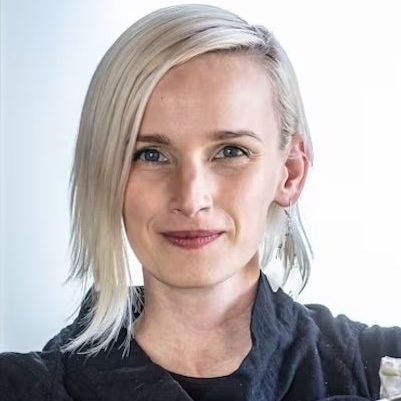 A photo of Char McCurdy, a woman with light blonde hair, wearing a black top