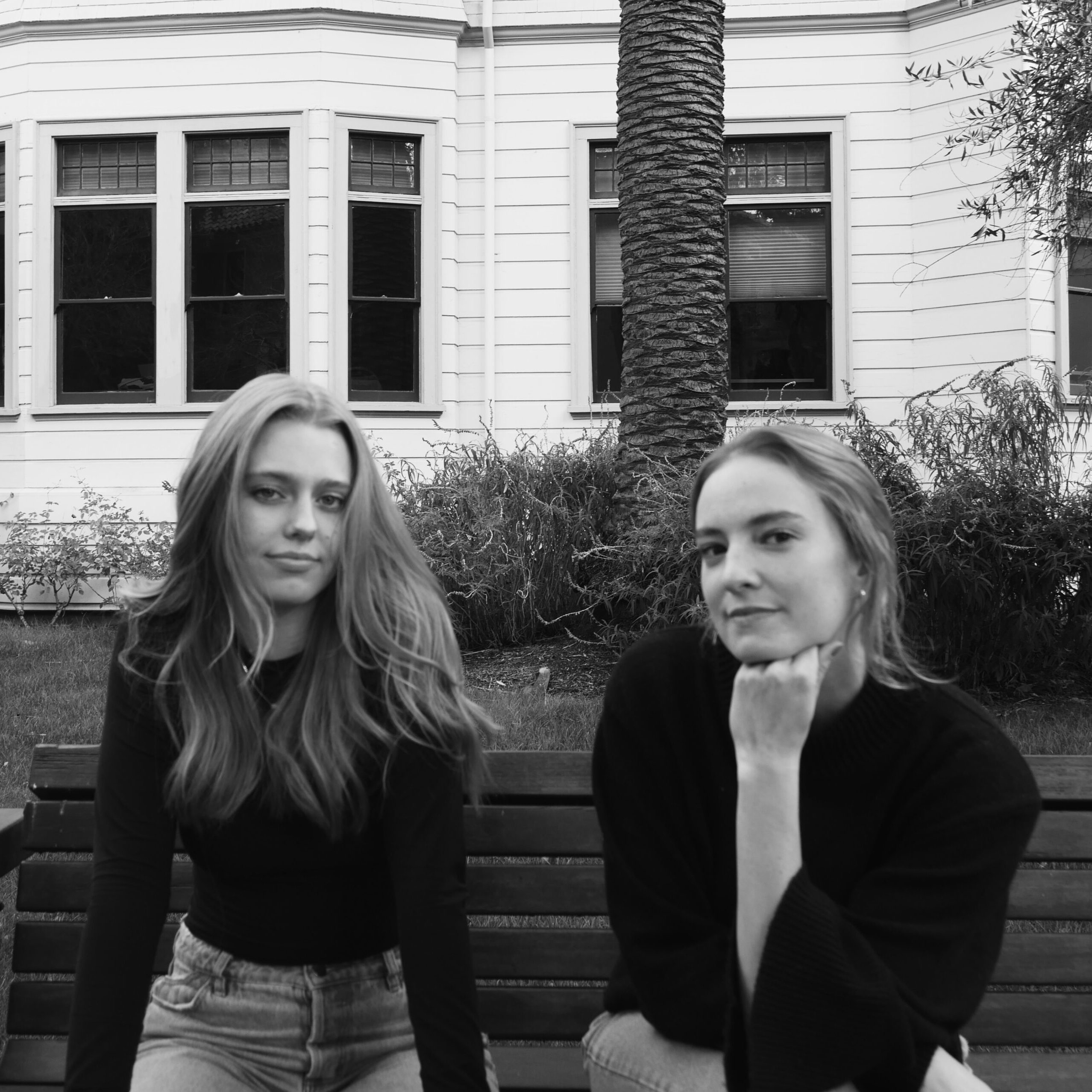 Black and white photo of Grace and Kyleigh sitting on a bench outside
