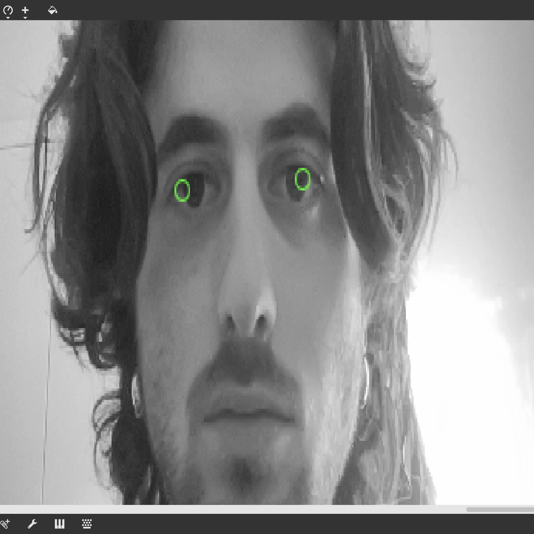 A black and white photo of Yonatan with bright green rings around his pupils