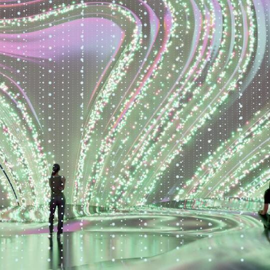 Wavy shapes displayed on a large digital screen in a room