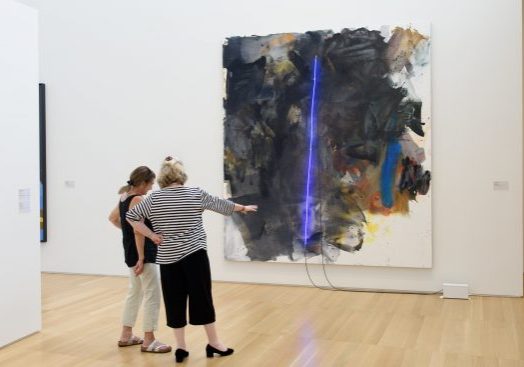 Anderson Collection patrons Christine Nicholas and Julia Procopé stop to discuss the Mary Weatherford’s, “black painting” a gift of Debra and Steven Wisch'83, in honor of the Anderson family.