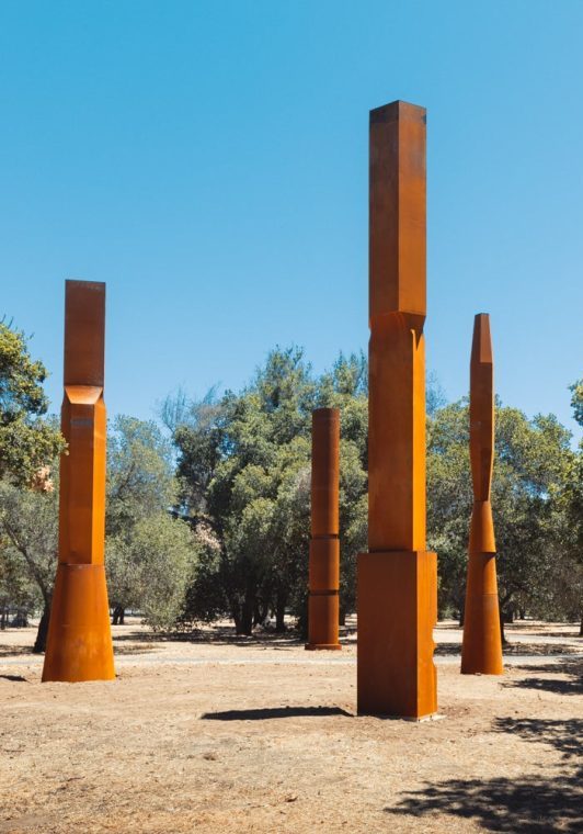 “The Stanford Columns” (2022), an installation at the Stanford Arboretum of four oxidized steel columns by award-winning American sculptor and environmental artist Beverly Pepper, is an iteration of an installation in Italy created specifically for the Stanford campus. | Andrew Brodhead