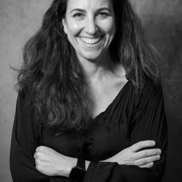 A person with long hair smiling at the camera