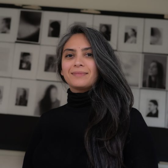 A person with long hair smiling towards the camera.