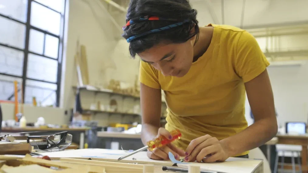 A woman designing wood work during Arts Intensive