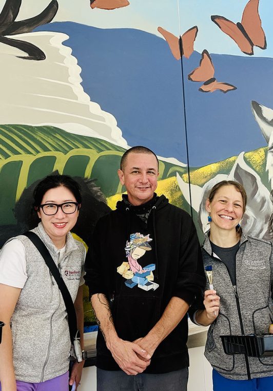 Staffers Jeanie Liang, Hyun Lee, Amy Huffaker, and Antonia Dapena-Tretter helped to paint a mural created by artist Ryan Martinez (center), featuring California landscapes and animals.