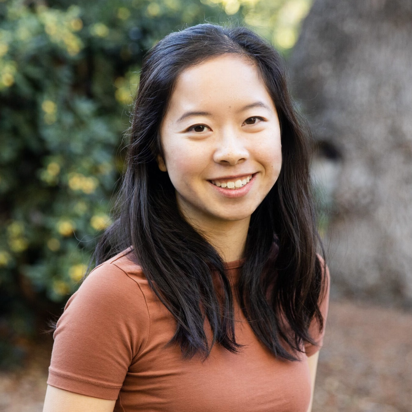 Photo of Jeiru Fang, an Asian woman with shoulder-length black hair in a rust colored t shirt